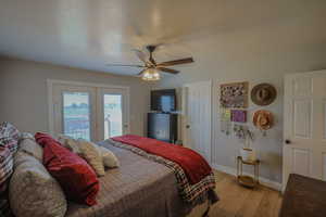 Bedroom featuring light hardwood / wood-style flooring, a textured ceiling, access to outside, and ceiling fan