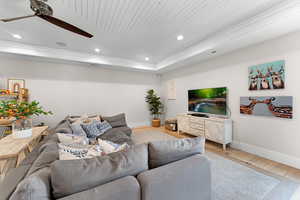 Living room featuring hardwood / wood-style floors, a tray ceiling, wooden ceiling, and ceiling fan