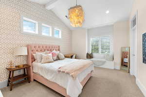 Carpeted bedroom with vaulted ceiling with beams, multiple windows, and a chandelier