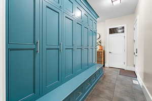 Mudroom with dark tile patterned floors