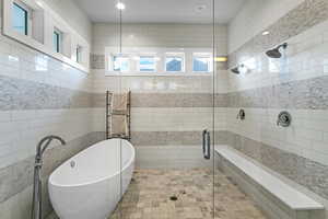 Bathroom featuring plus walk in shower and tile walls