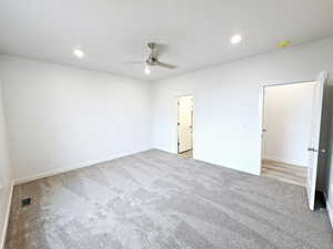 Unfurnished bedroom featuring light carpet and ceiling fan