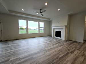 Unfurnished living room featuring light hardwood / wood-style flooring, a brick fireplace, and ceiling fan