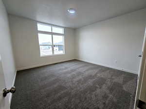 Carpeted spare room with a textured ceiling