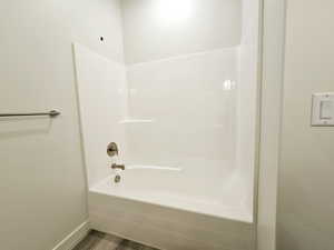 Bathroom with shower / washtub combination and hardwood / wood-style floors