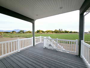 Wooden terrace featuring a yard, a mountain view, and a rural view