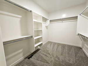 Walk in closet featuring dark carpet