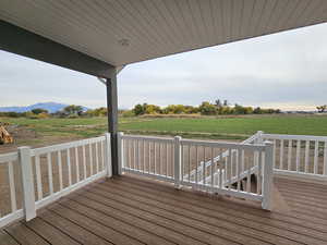 Wooden terrace featuring a rural view and a mountain view