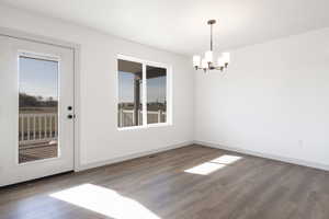 Unfurnished dining area with plenty of natural light, a chandelier, and hardwood / wood-style flooring