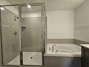 Full bathroom with vanity, shower with separate bathtub, a textured ceiling, and toilet