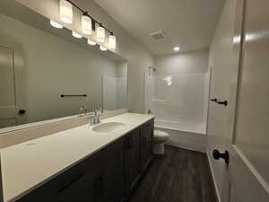 Full bathroom with vanity, hardwood / wood-style floors, toilet, and shower / bathtub combination