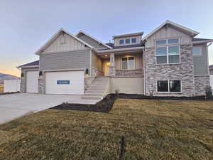 View of front of property featuring a garage and a yard