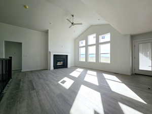 Unfurnished living room featuring light hardwood / wood-style floors, lofted ceiling, and ceiling fan