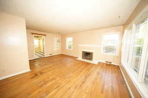 Unfurnished living room featuring a textured ceiling and light hardwood / wood-style flooring