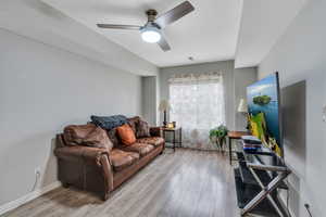 Living room with ceiling fan and light wood-type flooring