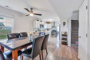 Dining area featuring light wood-type flooring and ceiling fan