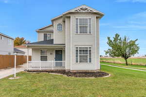 Front of property with covered porch and a front lawn