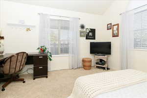 Carpeted bedroom featuring vaulted ceiling