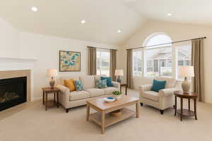 Living room with light colored carpet, recessed lighting, a fireplace with flush hearth, and high vaulted ceiling