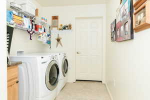 Laundry area featuring washing machine and dryer and light tile patterned flooring