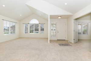 Foyer with vaulted ceiling, light carpet, baseboards, and recessed lighting