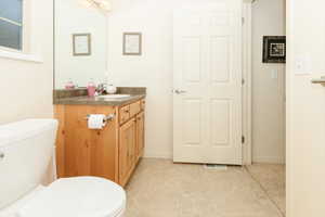 Bathroom featuring vanity, toilet, and tile patterned floors