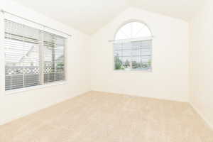 Unfurnished room with carpet, lofted ceiling, and baseboards