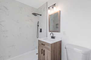 Full bathroom with vanity, tiled shower / bath, and toilet