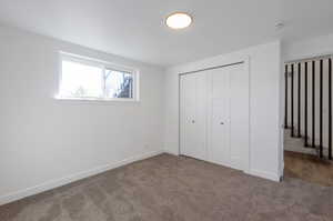 Unfurnished bedroom with a closet and dark carpet