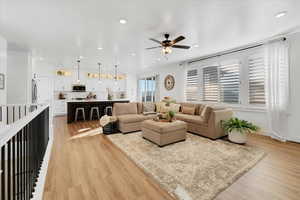 Living room with ceiling fan and light wood-type flooring