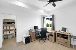 Office area featuring light colored carpet and ceiling fan