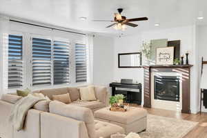 Living room with light wood-type flooring and ceiling fan