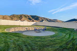 View of yard with an outdoor fire pit, a mountain view, and a patio area