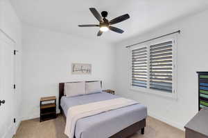 Carpeted bedroom with ceiling fan