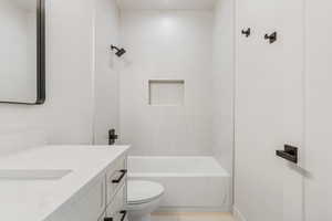 Full bathroom featuring vanity, toilet, and tiled shower / bath