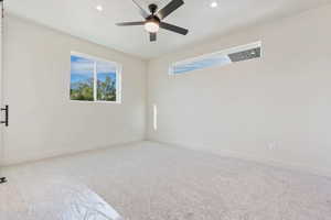 Carpeted spare room featuring ceiling fan