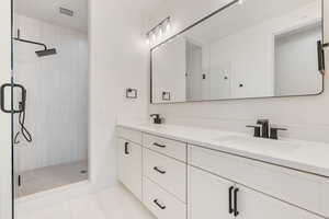 Bathroom with vanity, tile patterned flooring, and an enclosed shower