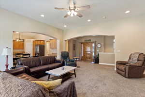 Carpeted living room with ceiling fan