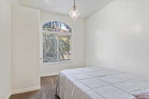 Carpeted bedroom with a chandelier