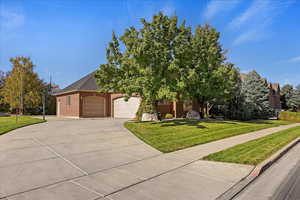 View of front of property featuring a front lawn and a garage