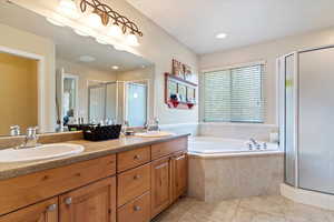 Bathroom with vanity, plus walk in shower, and tile patterned flooring