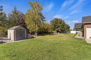 View of yard featuring central AC and a shed