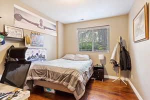 Bedroom with dark hardwood / wood-style flooring