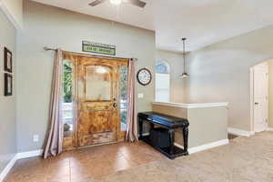 Foyer entrance featuring carpet and ceiling fan