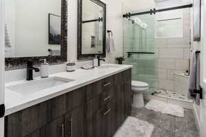 Bathroom featuring vanity, toilet, and a shower with shower door