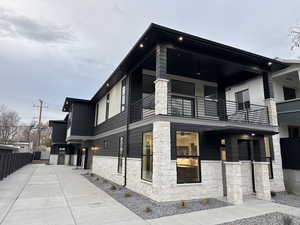 View of side of home featuring ceiling fan and a balcony