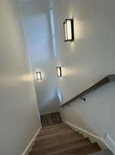 Stairway featuring hardwood / wood-style flooring