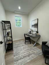 Office with light hardwood / wood-style flooring