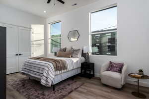 Bedroom with hardwood / wood-style floors, a closet, and ceiling fan