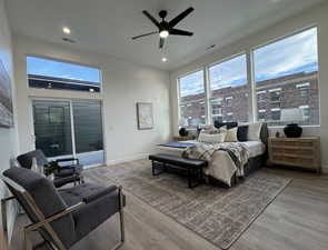 Bedroom with ceiling fan, light wood-type flooring, and access to exterior